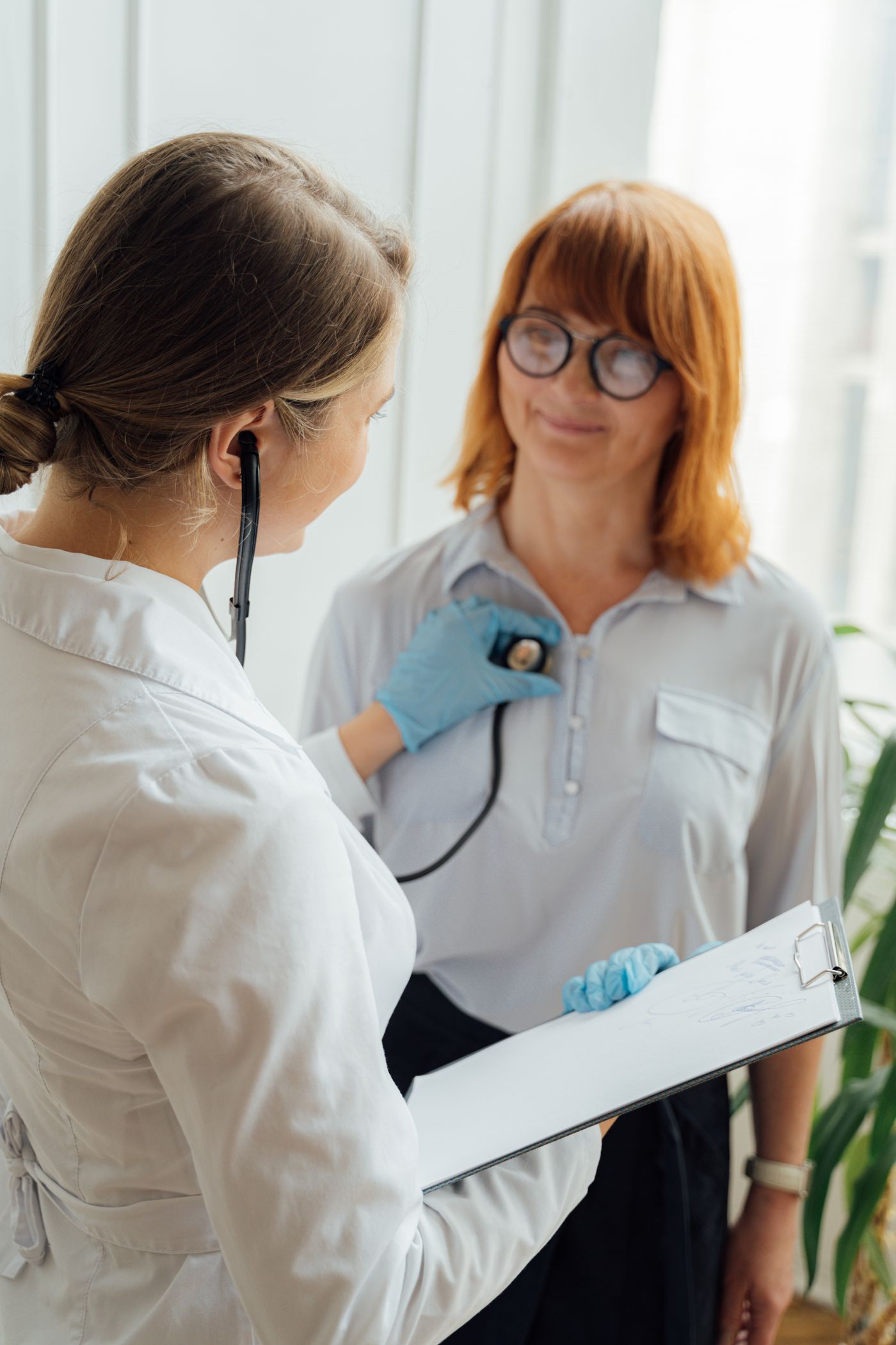 A clinician using a stethoscope during a patient examination
