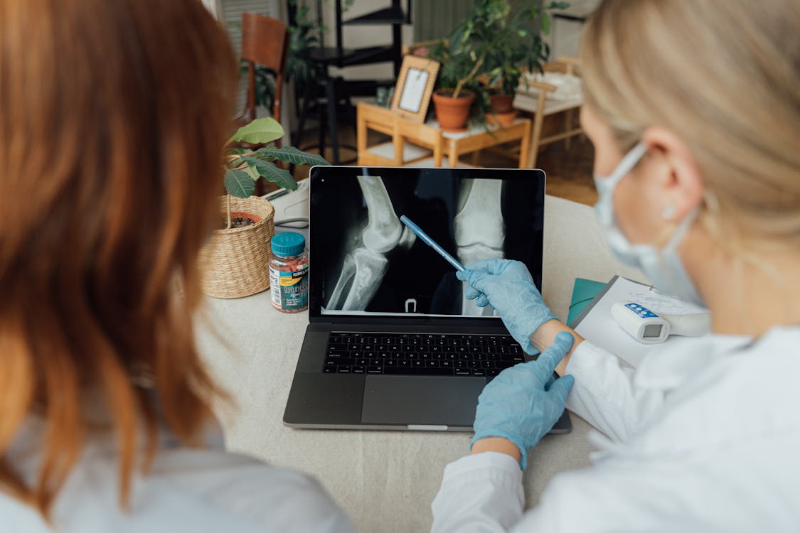 Free Doctors Examining an X Ray Image on a Laptop Stock Photo