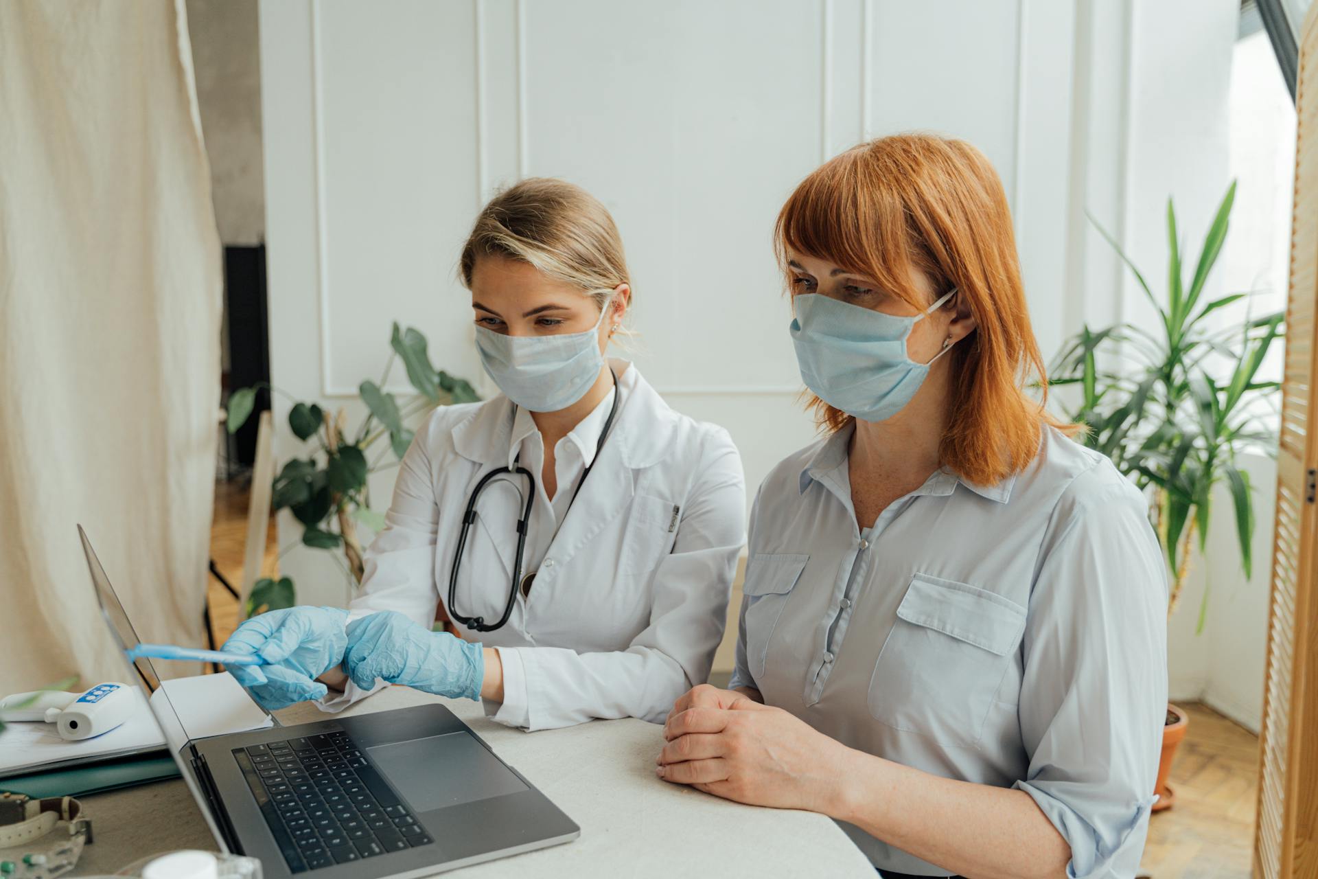 Doctor and patient wearing masks in a consultation, ensuring safety with protective measures.