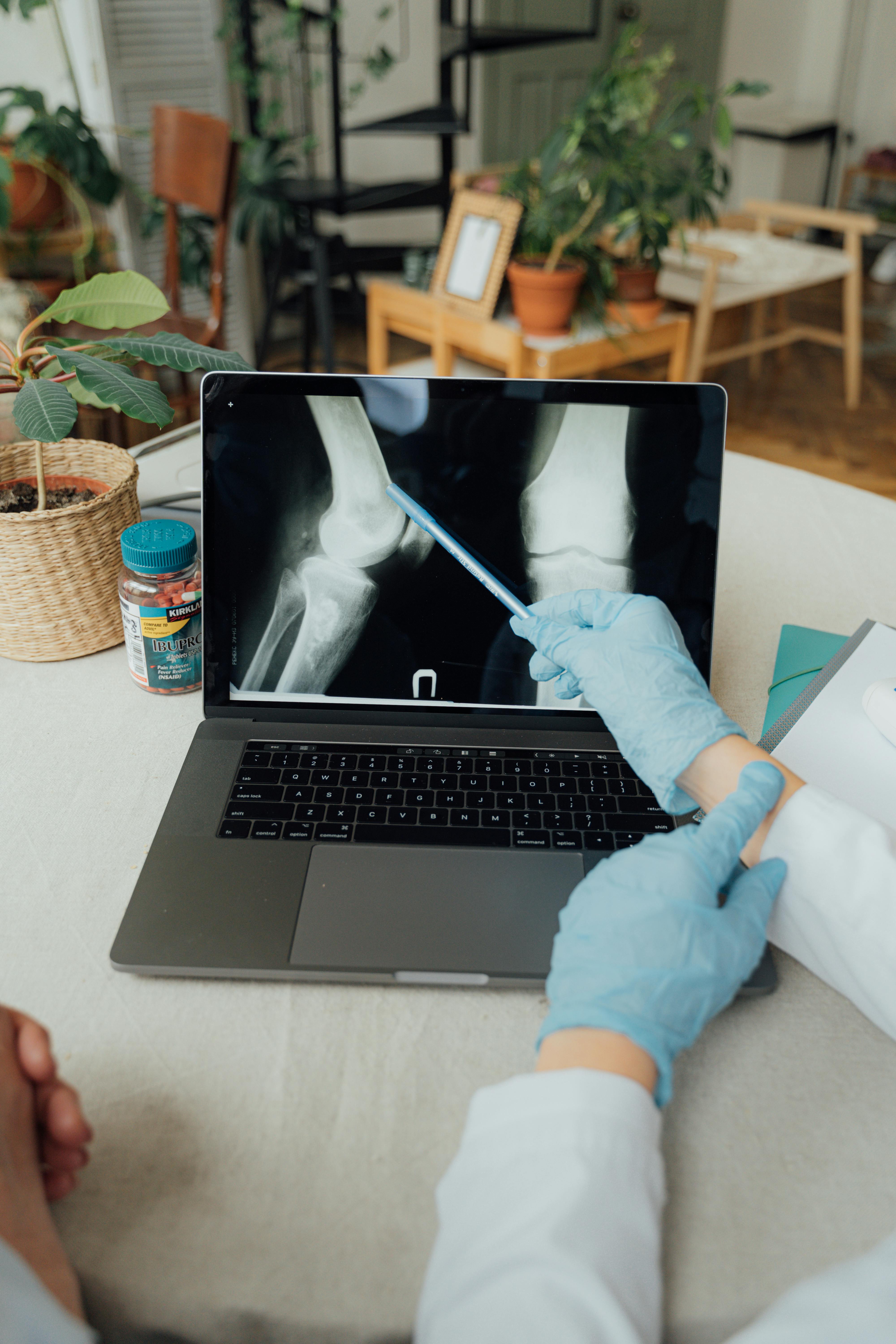 person using macbook pro on white table