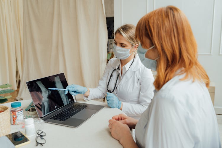 Doctors Examining An X Ray Image On A Laptop