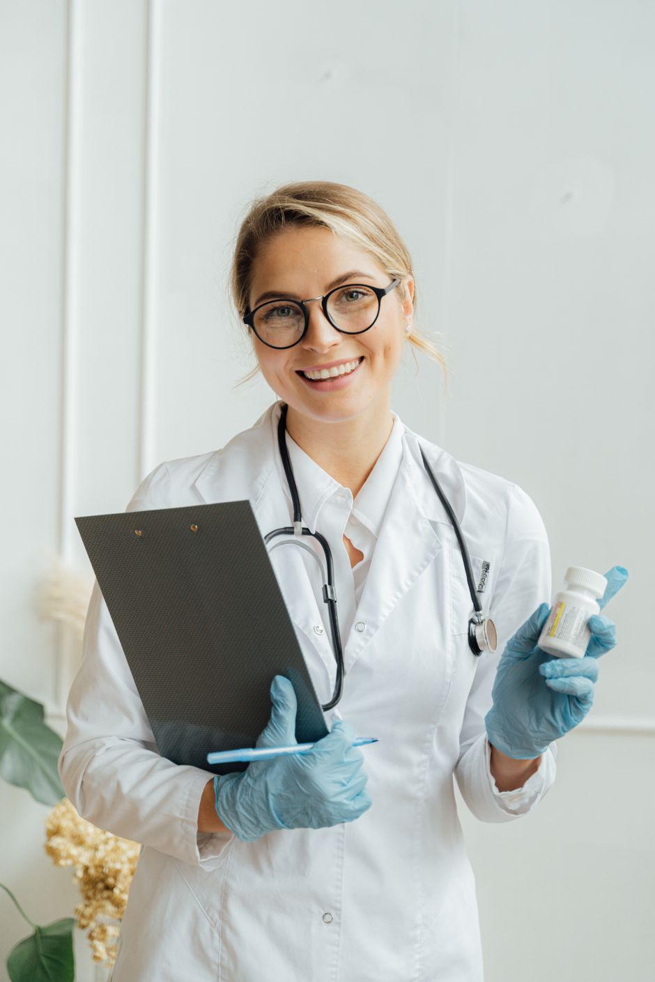 A cheerful physician holding a clipboard and medication