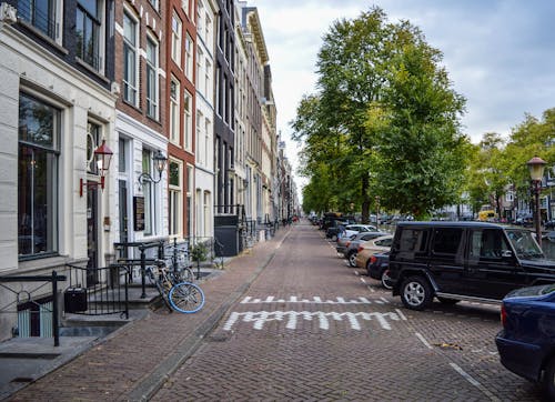 Free Empty paved sidewalk near aged buildings Stock Photo