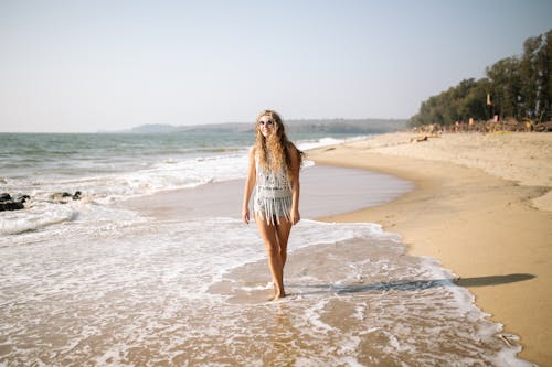Woman Walking Along the Beach and Smiling 