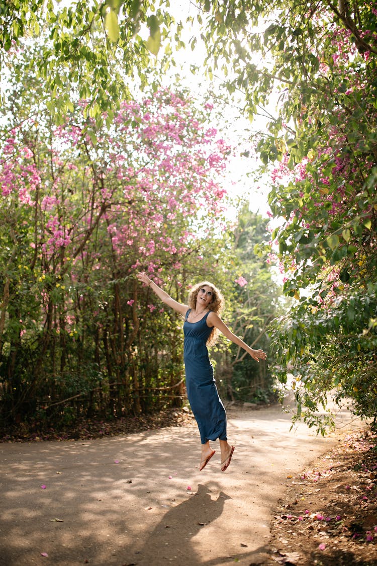 Happy Woman Jumping In Summer Park