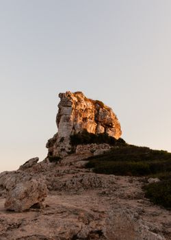 西班牙日落温暖的光芒，照亮了干旱景观中令人惊叹的岩石结构，展现出独特的美