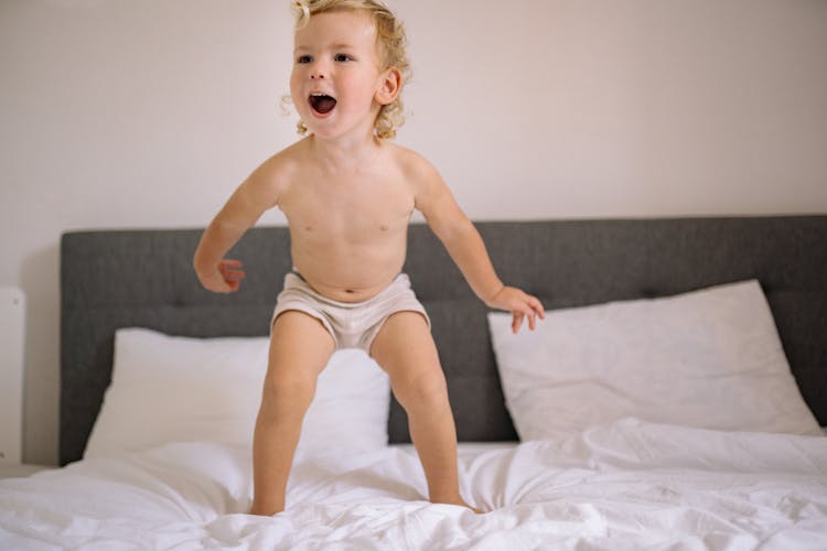 Happy Baby Jumping On A Bed 