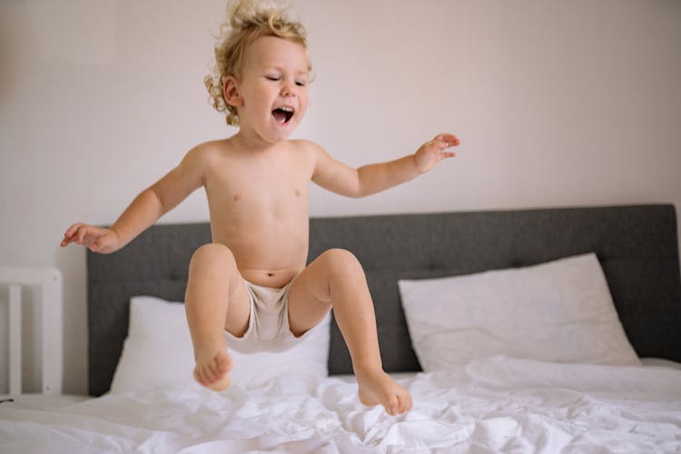 Boy Jumping On Bed