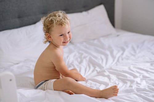 Free Cute Toddler Sitting in Bed Stock Photo