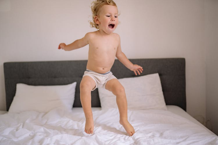 A Kid Jumping On The Bed