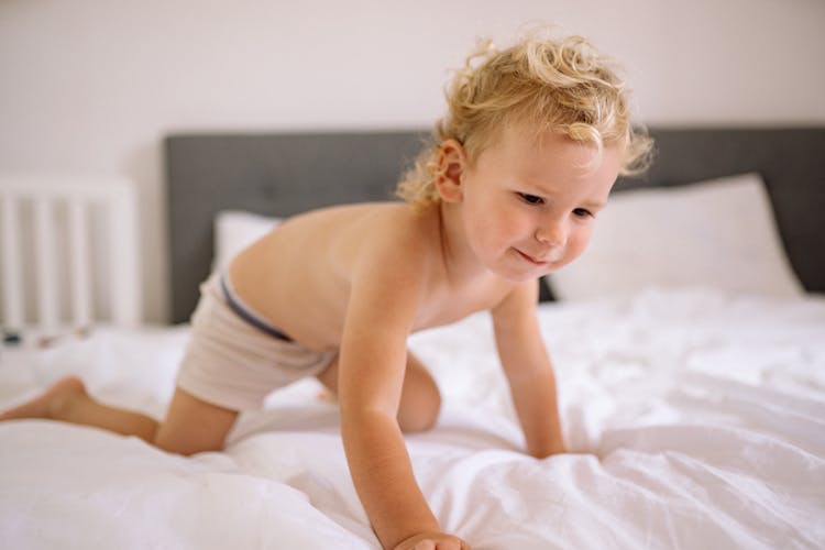 Little Kid Crawling On Bed At Home