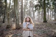 Woman in Gray Long Sleeve Dress Standing on Brown Dried Leaves