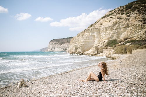 Free Woman in Black Bikini Sitting on Beach Stock Photo