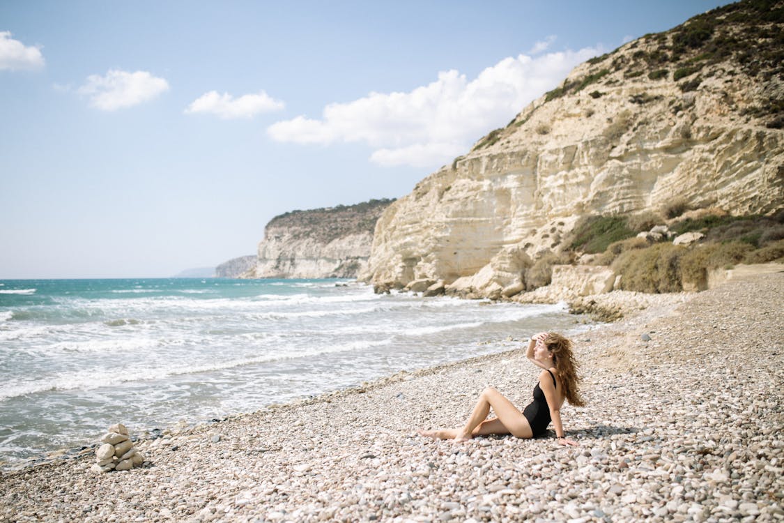 Free Woman in Black Bikini Sitting on Beach Stock Photo