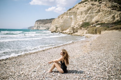 Free Woman in Black Bikini Sitting on Beach Shore Stock Photo