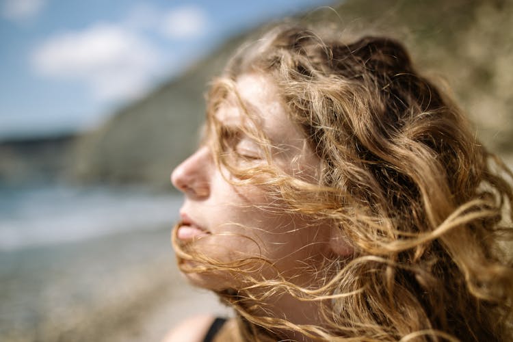 Close-up Of Woman Enjoying Summer Breeze At Sea