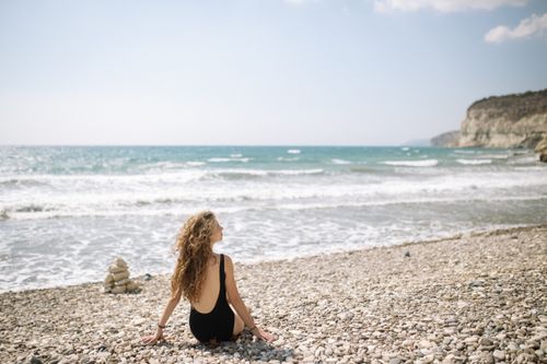Woman in Black Bikini Sitting on Beach Shore · Free Stock Photo