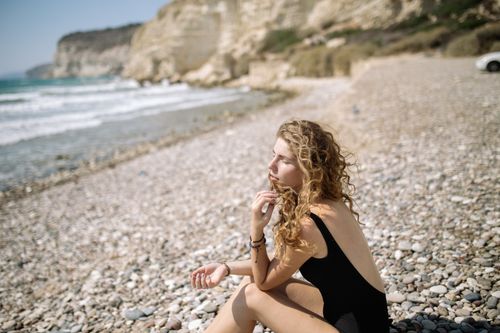 Woman in Black Bikini Sitting on Beach Shore · Free Stock Photo