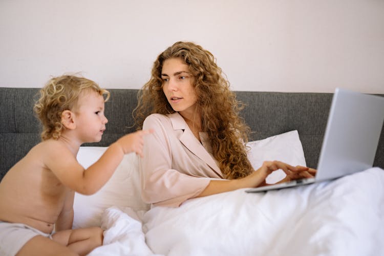 A Shirtless Toddler Pointing At The Laptop Screen