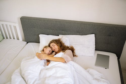 Free A Mother and Toddler Lying on the Bed Together Stock Photo