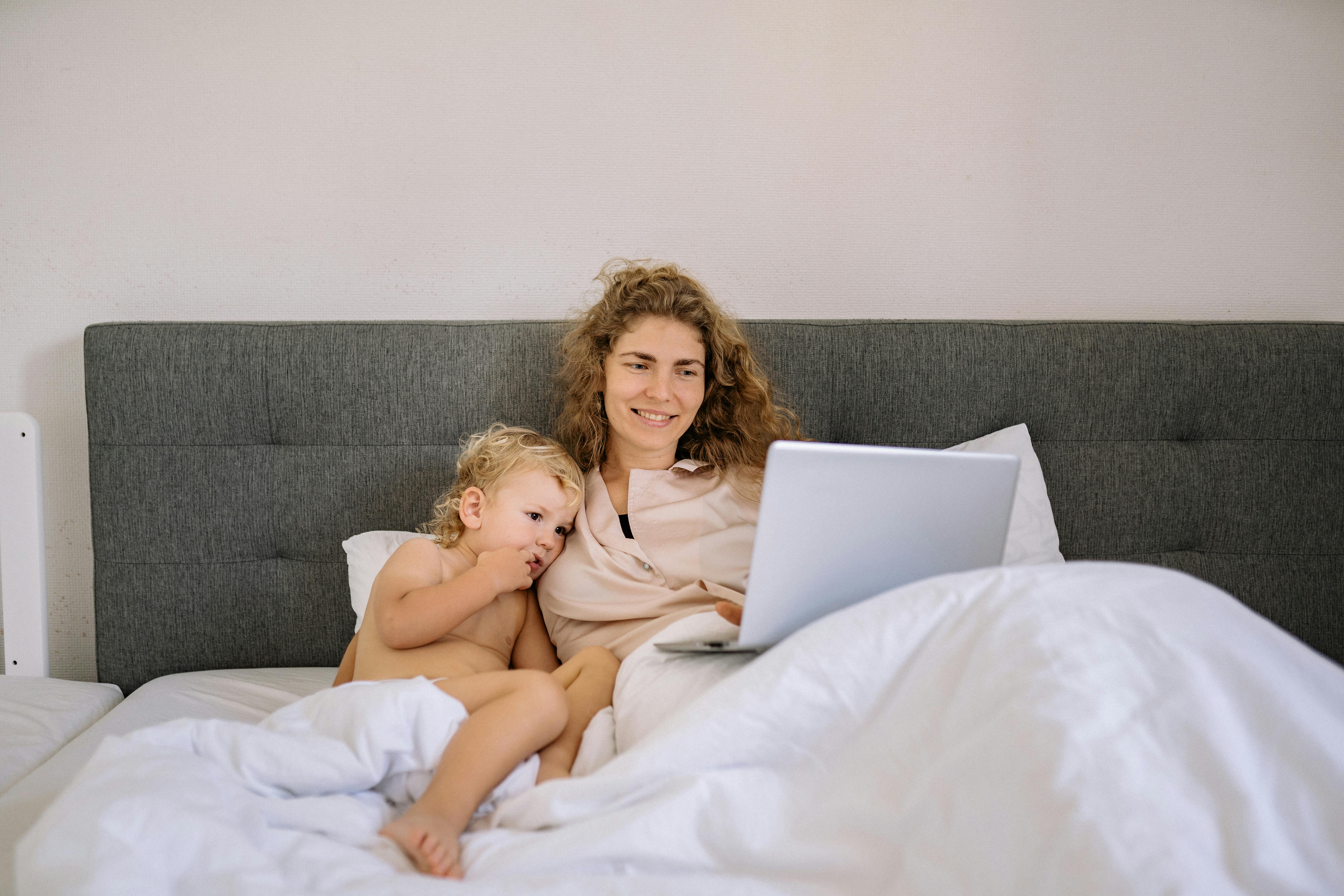 a woman and a child watching while in bed