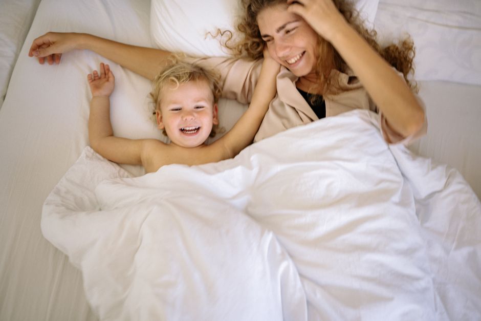 Photo by Yan Krukau on Pexels A joyful mother and child enjoying a playful moment together in bed. - Photo by Yan Krukau on Pexels