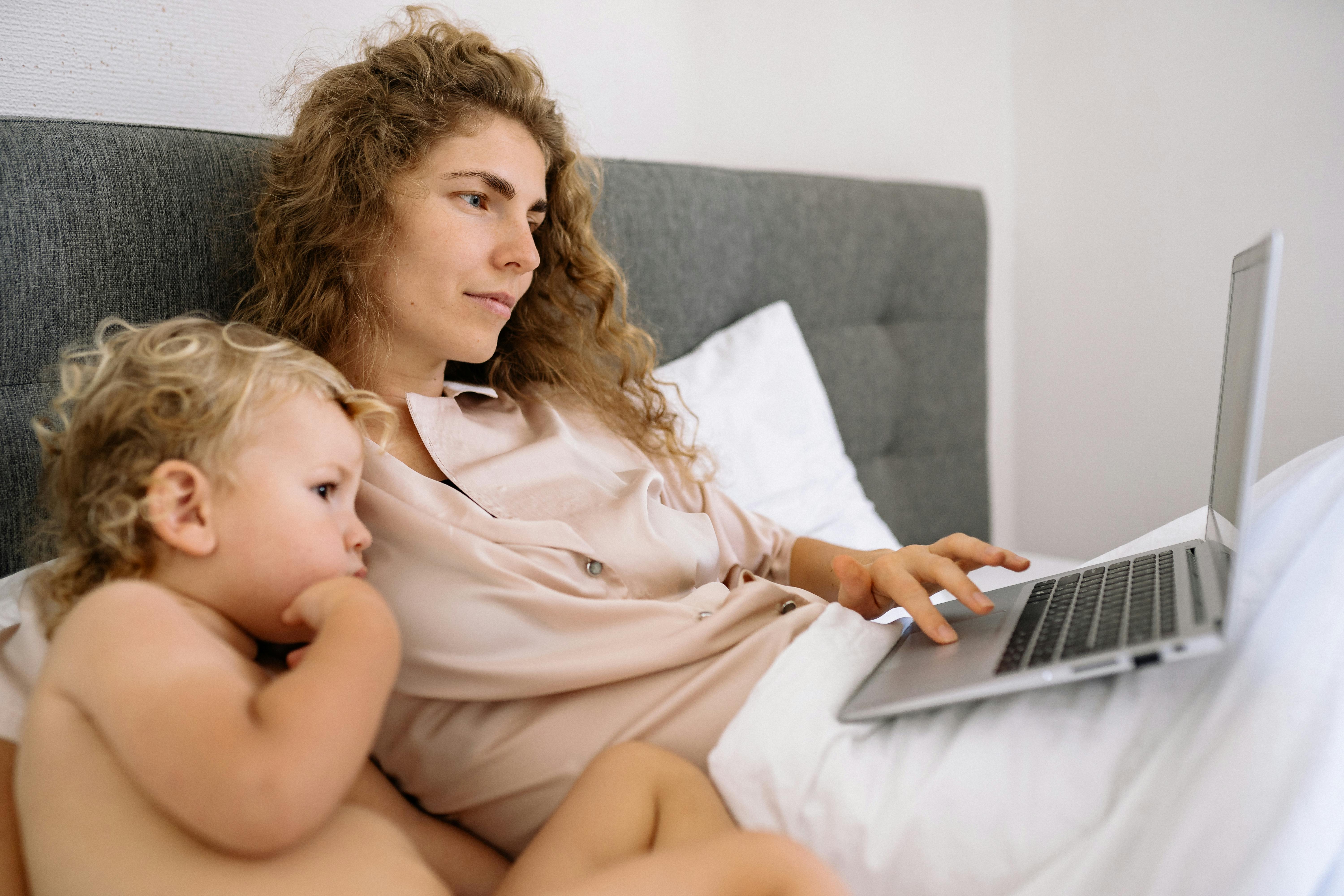 a woman and a kid looking at a laptop