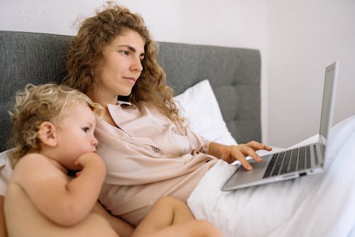 A Woman and a Kid Looking at a Laptop