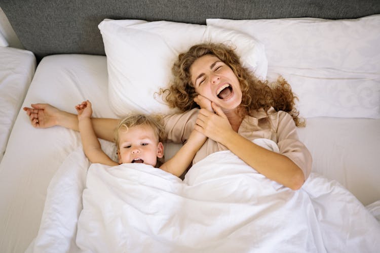 A Mother And Toddler Lying In Bed