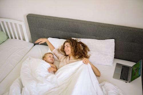 A Woman and a Toddler Lying on the Bed