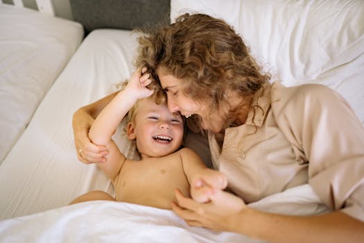 Joyful mother and child sharing a playful moment in bed. Heartwarming family scene.