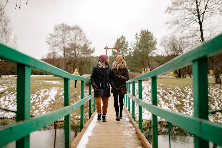 A Couple Walking On A Bridge 