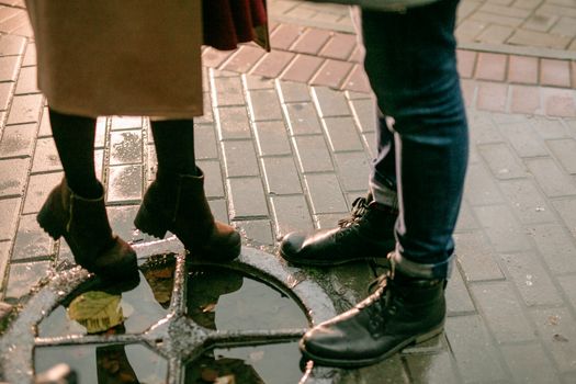 Close-up of Couple Legs near Hatch on Rainy Day