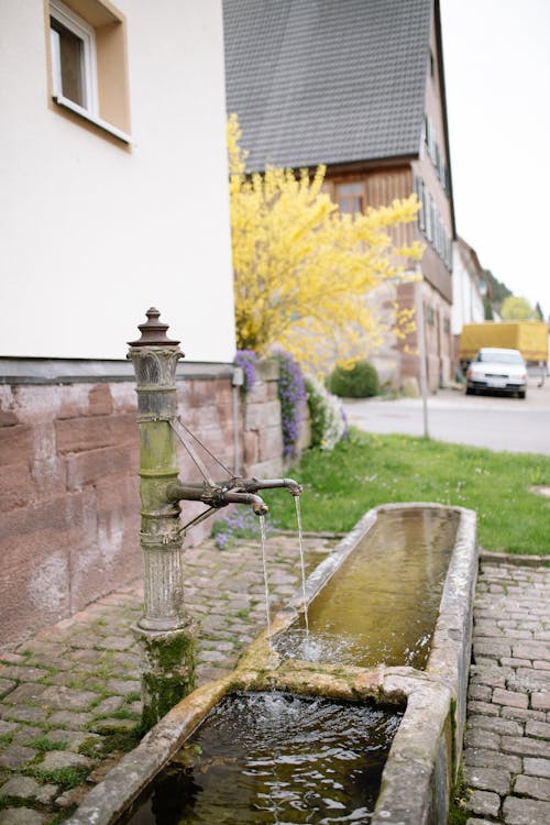 Free Antique Outdoor Water Faucet Next to a House  Stock Photo