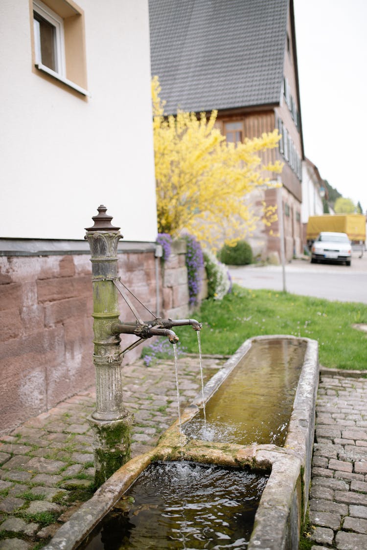 Antique Outdoor Water Faucet Next To A House 