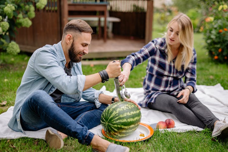 A Man Slicing A Watermelon