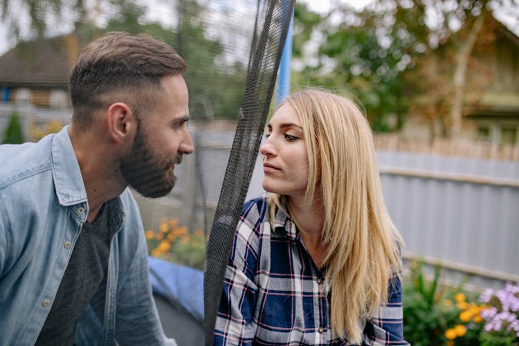 A Woman Looking At Her Man Behind A Net