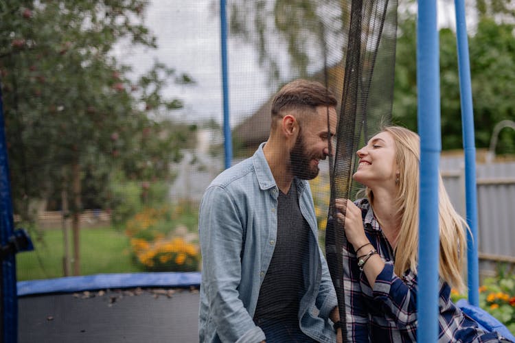 A Woman Looking At A Man In A Trampoline