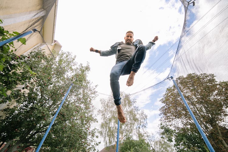 Cloudy Sky Above A Man Jumping On A Trampoline