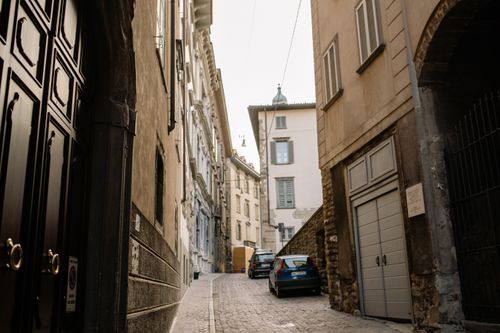 Free A picturesque narrow street in an old town with cobblestone paving and historic facades. Stock Photo