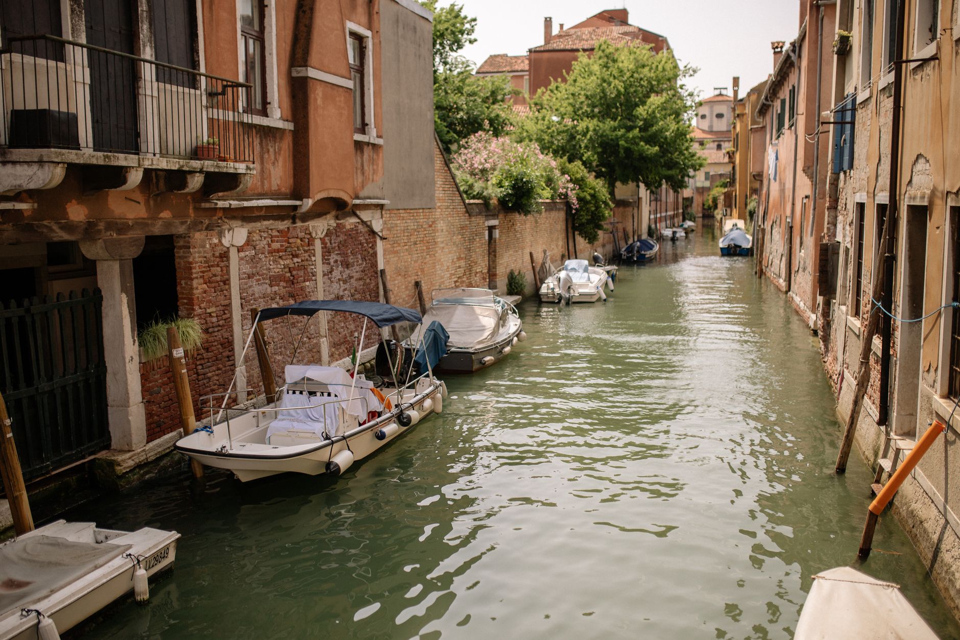 Picturesque canal in Venice lined with historic buildings and boats, capturing serene environment.