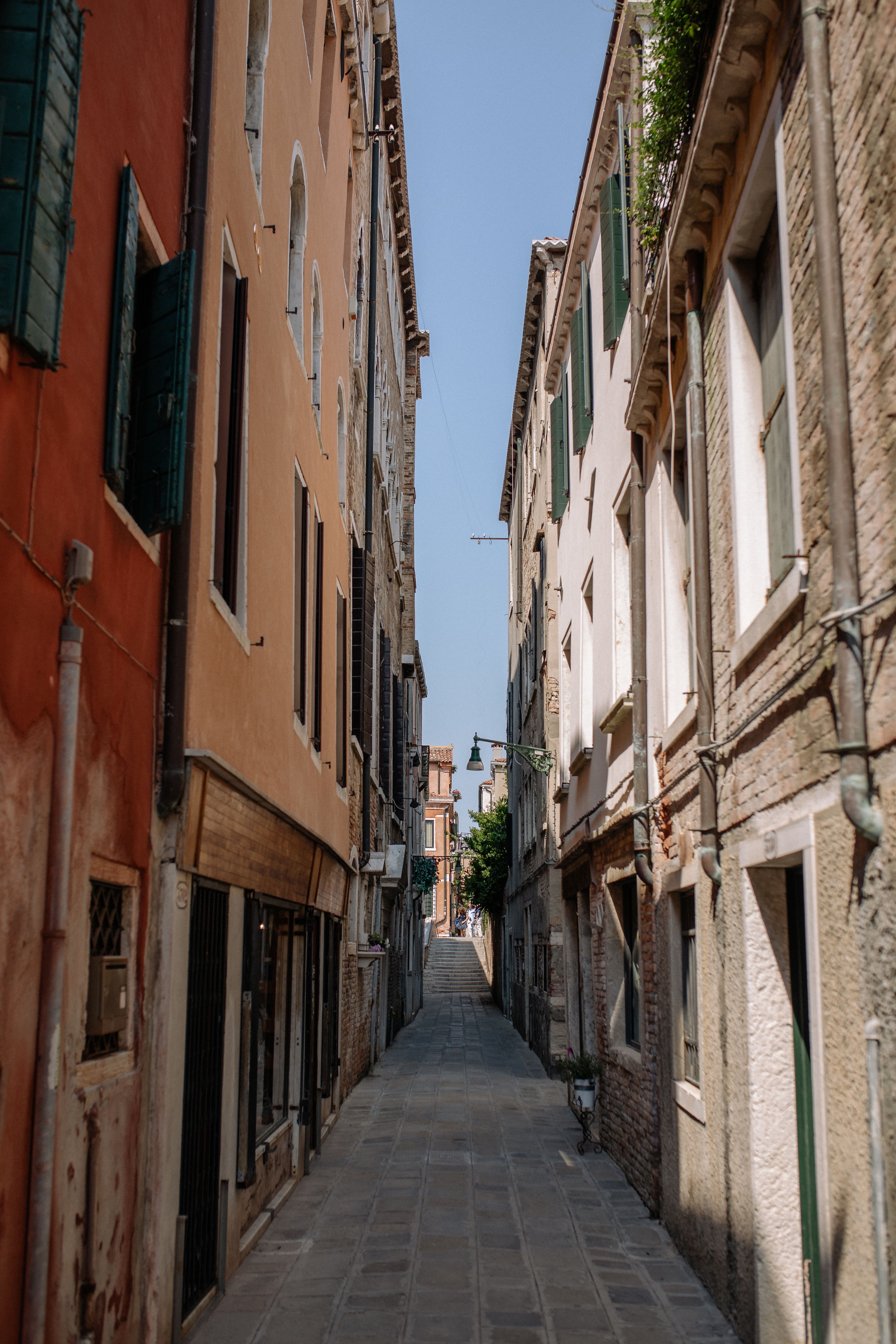 Ruelle pavée très étroite bordée d'immeubles anciens à volets, sans possibilité de stationnement.