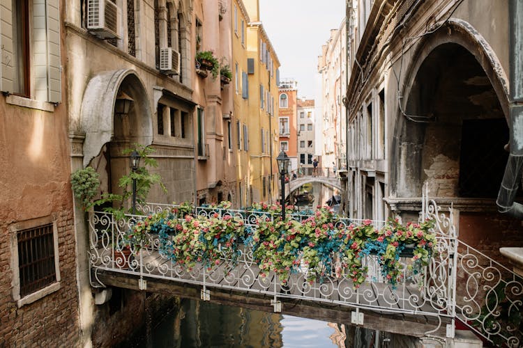 Bridge Between Building Covered In Flowers In Venice, Italy 