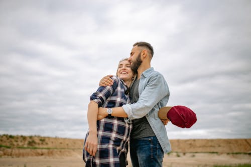 Man Hugging Smiling Pregnant Woman