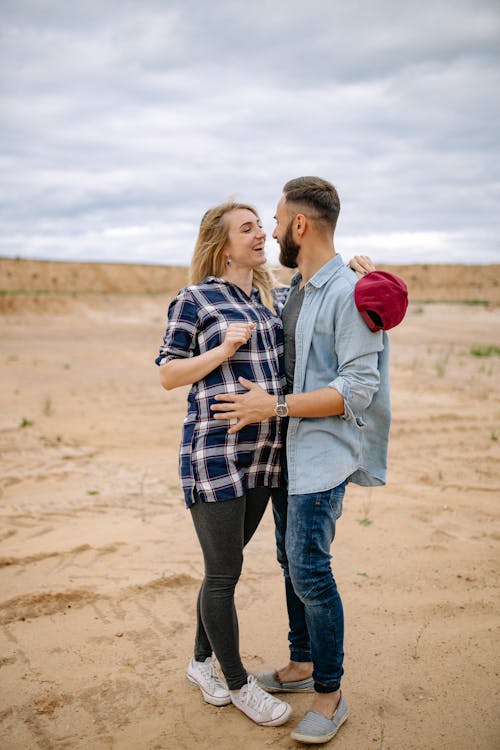 Woman and Man Hugging under Clouds