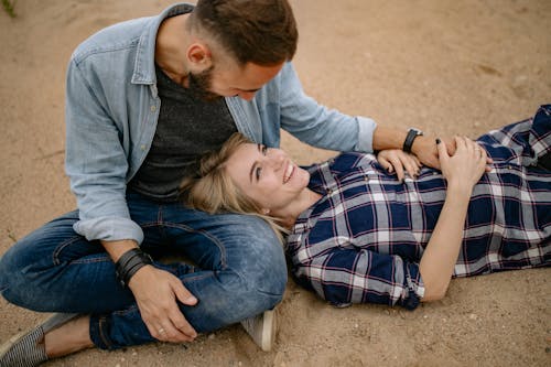 Pregnant Woman Lying With Her Head on Her Partners Lap and Smiling