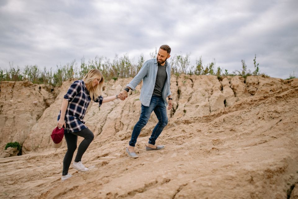 A couple hiking hand in hand on a rocky trail
