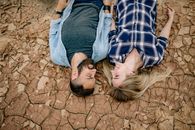 Man in Gray Shirt Lying on Brown Sand