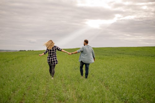 Man and Woman Holding Hands on Field