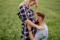 一对恩爱的夫妇在宁静的户外环境中相拥，妻子正怀着身孕